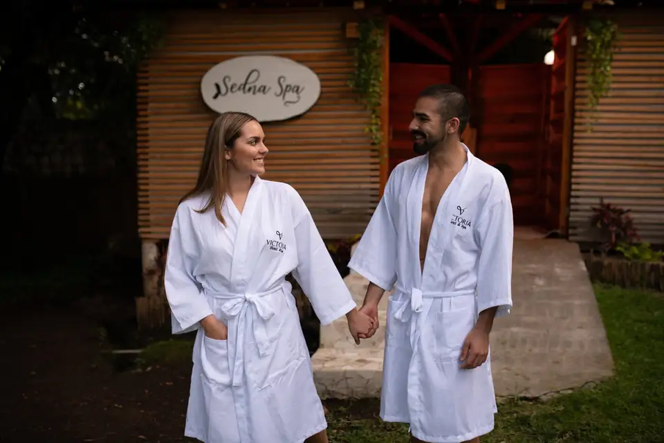 Pareja en bata frente a la entrada de Sedna Spa